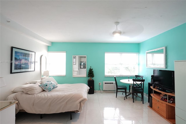 bedroom with a wall unit AC, light tile flooring, and ceiling fan