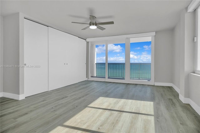 empty room with ceiling fan and light wood-type flooring