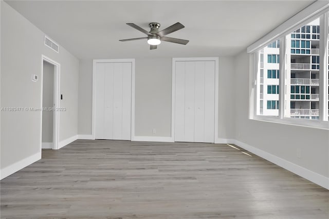 unfurnished room with plenty of natural light, ceiling fan, and light wood-type flooring