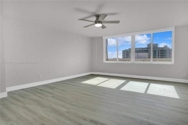 spare room with ceiling fan and light wood-type flooring