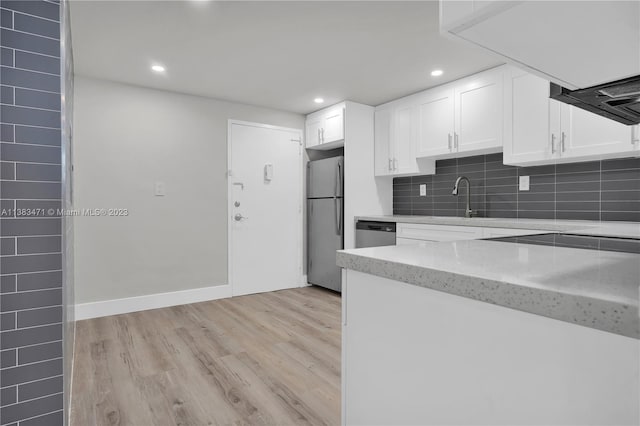 kitchen featuring light hardwood / wood-style floors, white cabinets, light stone countertops, and stainless steel appliances