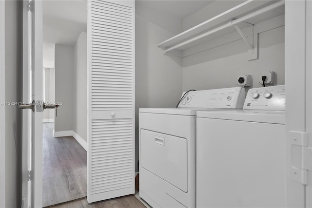 washroom featuring electric dryer hookup, light hardwood / wood-style flooring, and washing machine and dryer