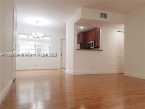 spare room featuring an inviting chandelier and light wood-type flooring