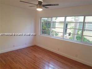 unfurnished room with ceiling fan and wood-type flooring