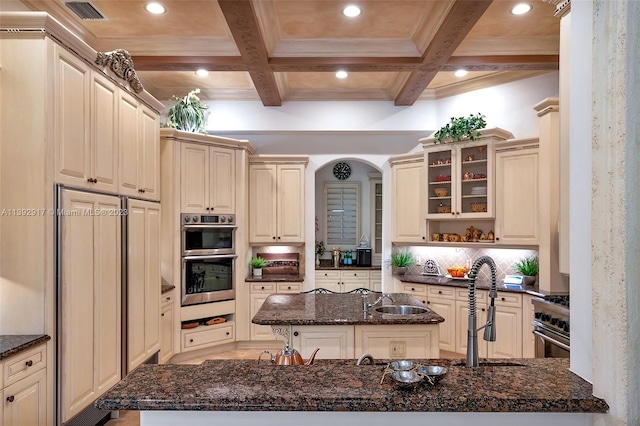 kitchen featuring coffered ceiling, tasteful backsplash, and dark stone counters