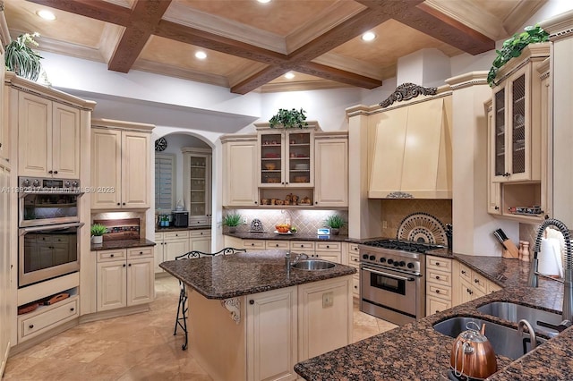 kitchen with coffered ceiling, tasteful backsplash, stainless steel appliances, and light tile floors