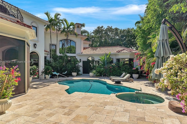 view of swimming pool featuring an in ground hot tub and a patio