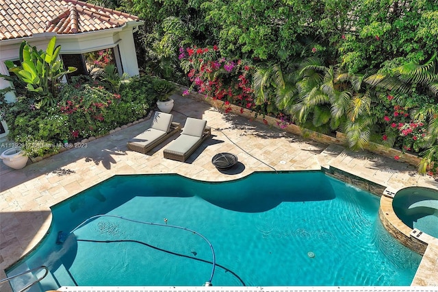 view of pool with an in ground hot tub and a patio