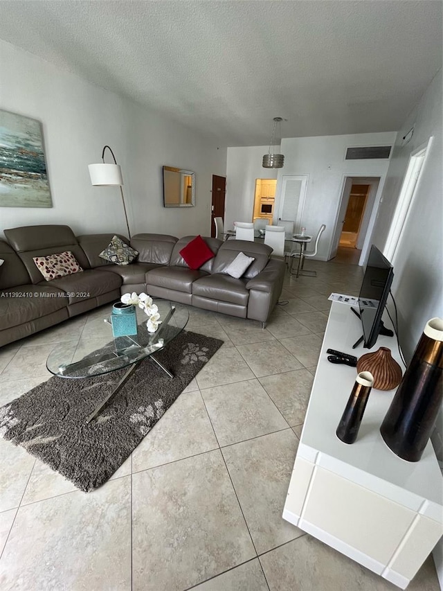 living room featuring a textured ceiling and tile flooring