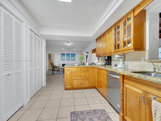 kitchen featuring kitchen peninsula, backsplash, light tile flooring, dishwasher, and light stone counters