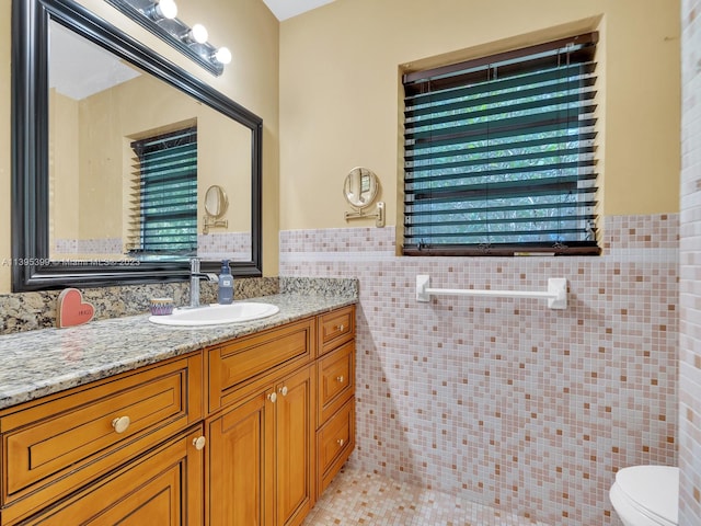 bathroom with tile walls, oversized vanity, tile floors, and toilet