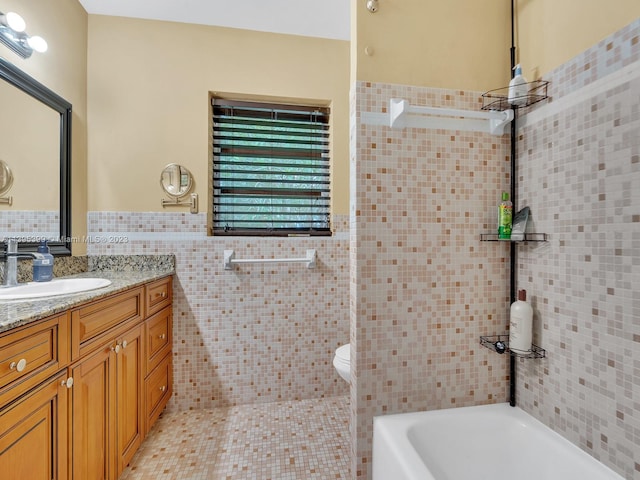 bathroom featuring vanity, toilet, and tile walls