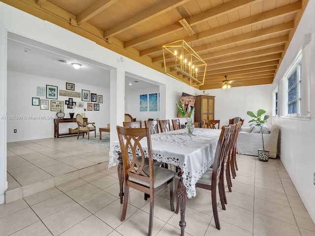 dining room with beamed ceiling, ceiling fan with notable chandelier, light tile floors, and wood ceiling