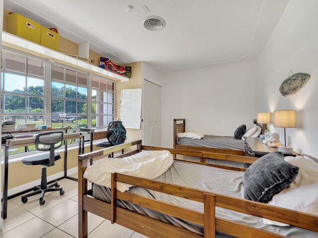 bedroom featuring a closet and light tile floors