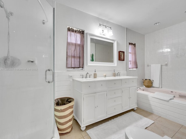 bathroom featuring tile flooring, double vanity, plenty of natural light, and independent shower and bath