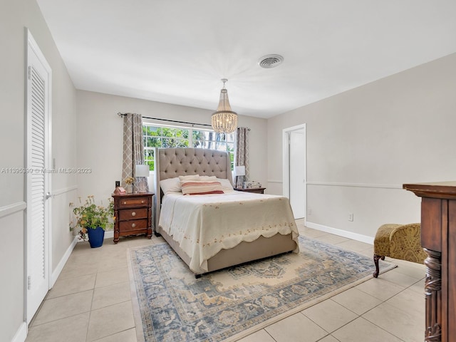 bedroom with a chandelier and light tile floors