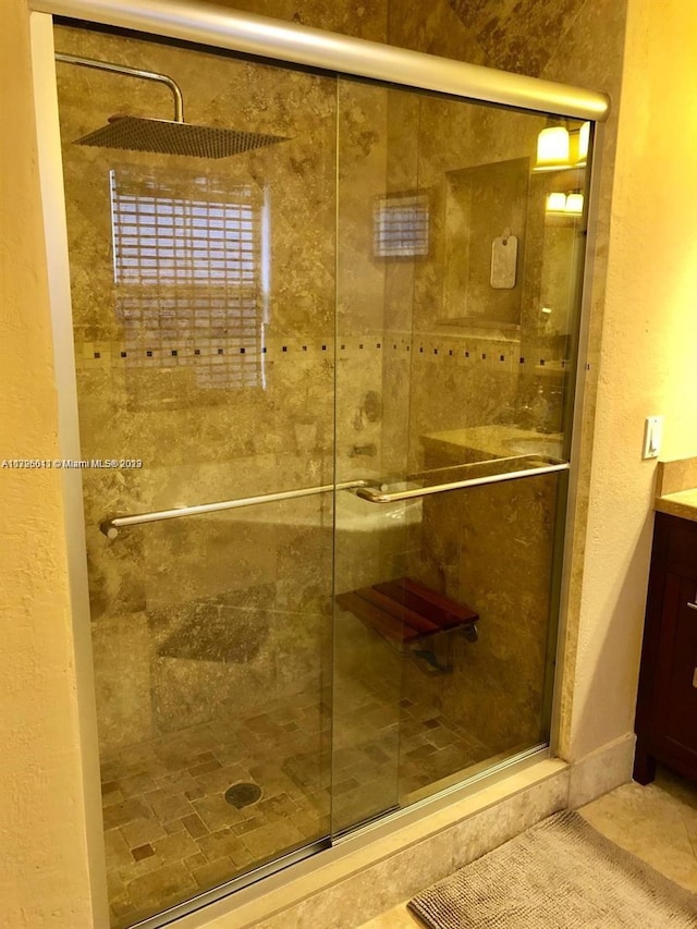 bathroom with vanity, tile floors, and a shower with door