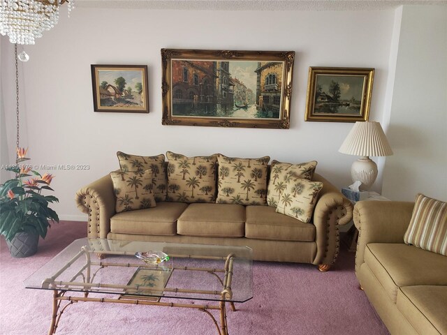 carpeted living room with a notable chandelier