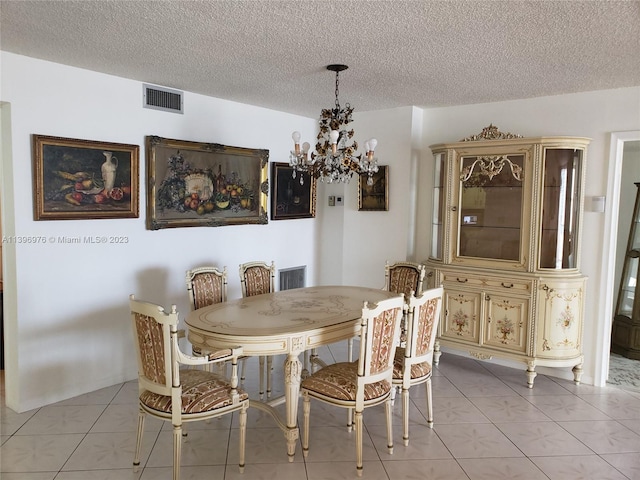 dining space featuring an inviting chandelier, a textured ceiling, and light tile flooring