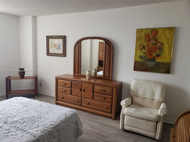 bedroom featuring a textured ceiling and light hardwood / wood-style floors