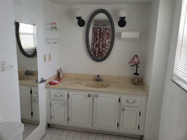 bathroom with toilet, vanity, and tile flooring