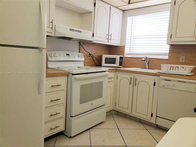 kitchen with light tile floors, tasteful backsplash, ventilation hood, and white appliances