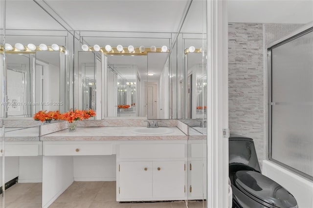 bathroom featuring tile patterned flooring, a shower with door, and vanity