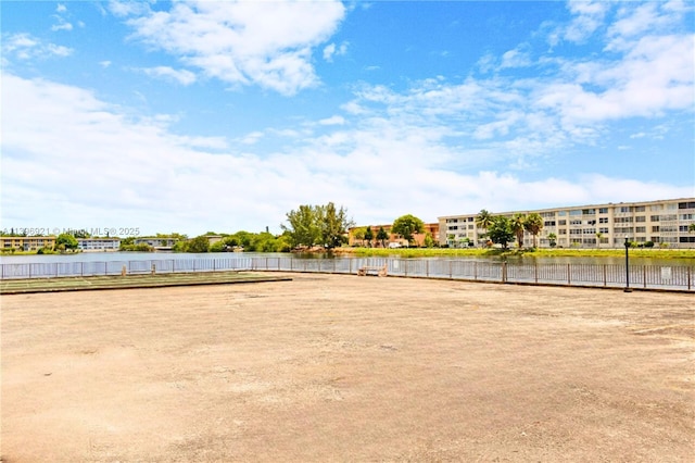 view of property's community with a water view and fence