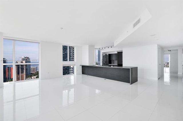 interior space with a healthy amount of sunlight, sink, and light tile floors