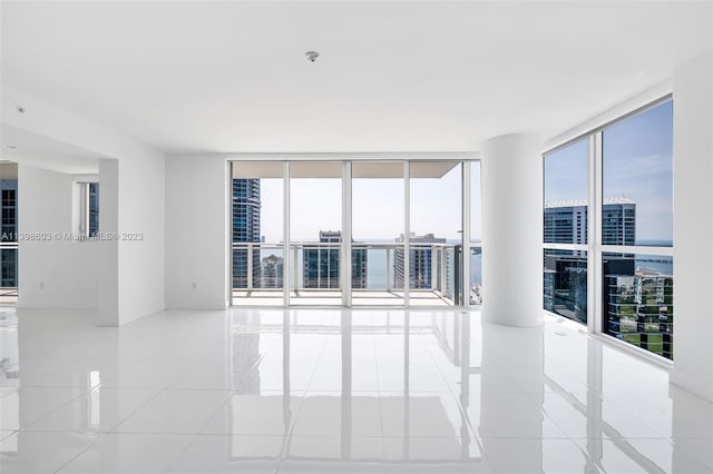 tiled empty room featuring floor to ceiling windows