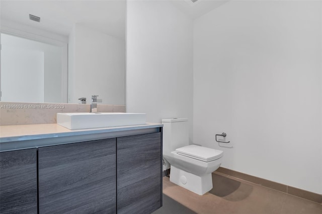 bathroom with concrete flooring, vanity, and toilet