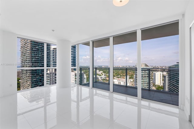 tiled empty room featuring floor to ceiling windows