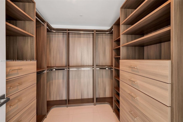 spacious closet with light tile floors