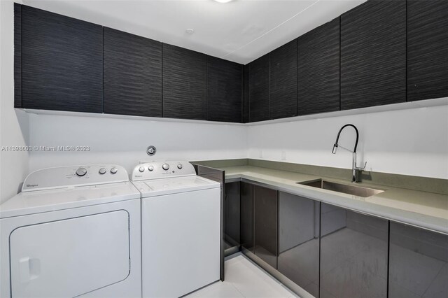 laundry room with washer and clothes dryer, light tile flooring, sink, and cabinets