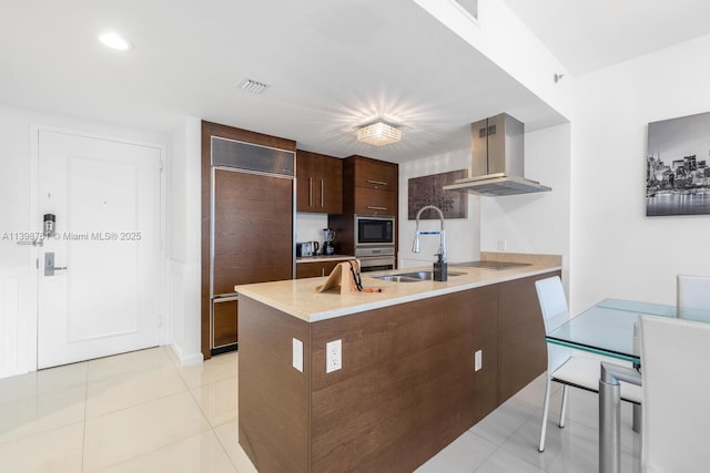 kitchen featuring black appliances, sink, island exhaust hood, light tile patterned floors, and dark brown cabinets