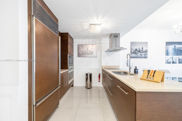 kitchen featuring extractor fan, paneled built in fridge, sink, light tile patterned floors, and black electric cooktop