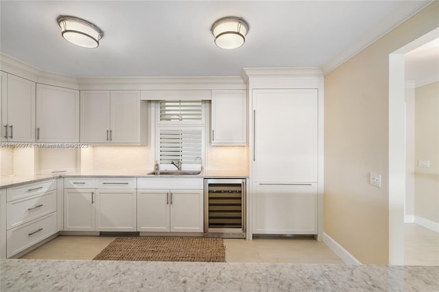 kitchen featuring backsplash, white cabinetry, wine cooler, and ornamental molding