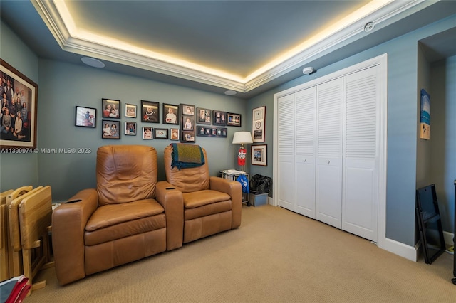 living area with ornamental molding, a raised ceiling, and light colored carpet