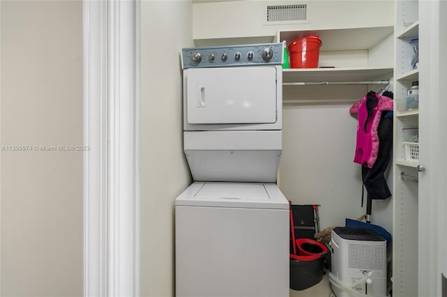 laundry room featuring stacked washer / drying machine