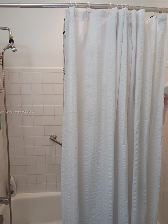 bathroom with shower / bathtub combination with curtain