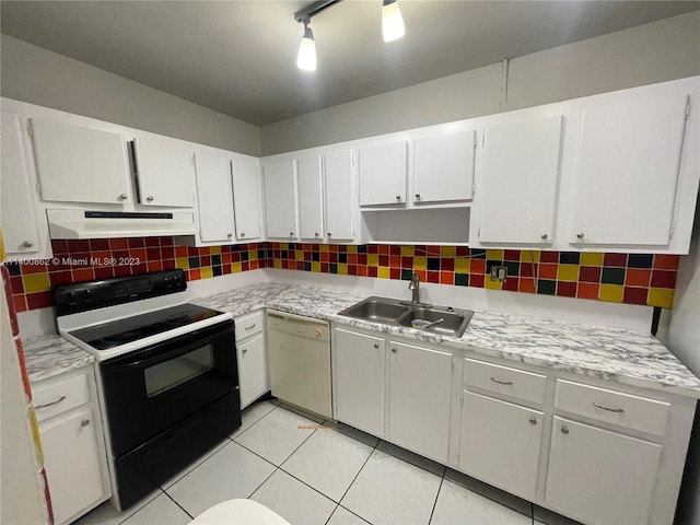 kitchen featuring white appliances, sink, light tile floors, white cabinets, and backsplash