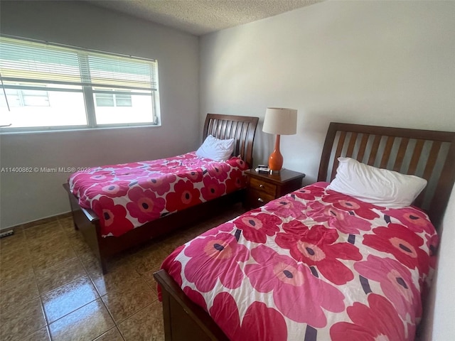 tiled bedroom with a textured ceiling