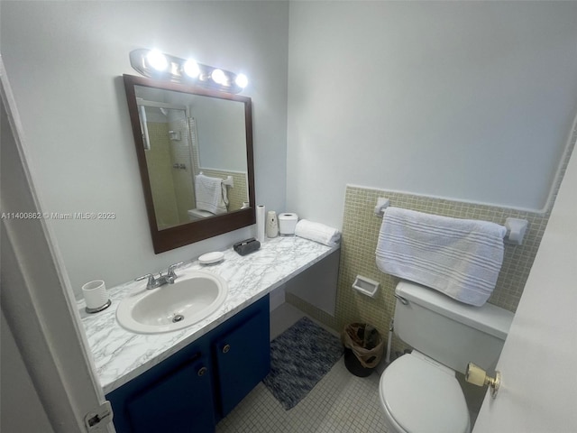 bathroom featuring toilet, large vanity, and tile floors