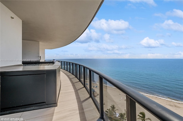 balcony featuring a water view and a view of the beach