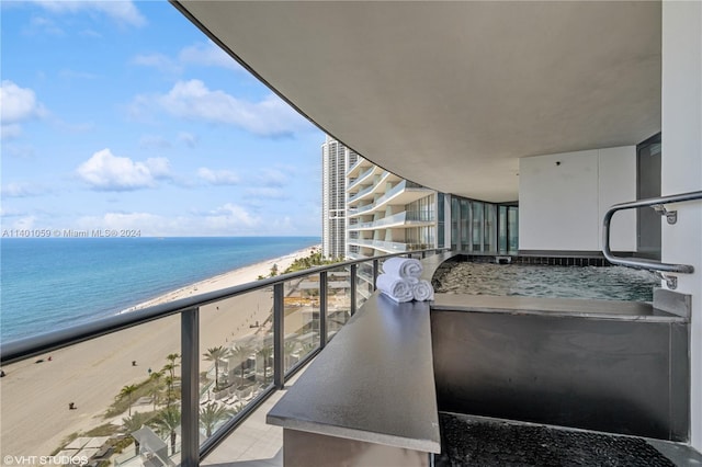 balcony featuring a beach view and a water view