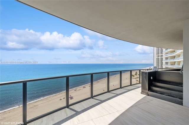 balcony featuring a beach view and a water view