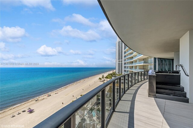 balcony featuring a water view and a beach view