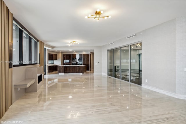 hall with a notable chandelier and light tile floors