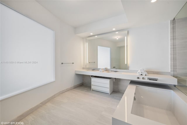 bathroom with tile flooring, vanity, and a tub