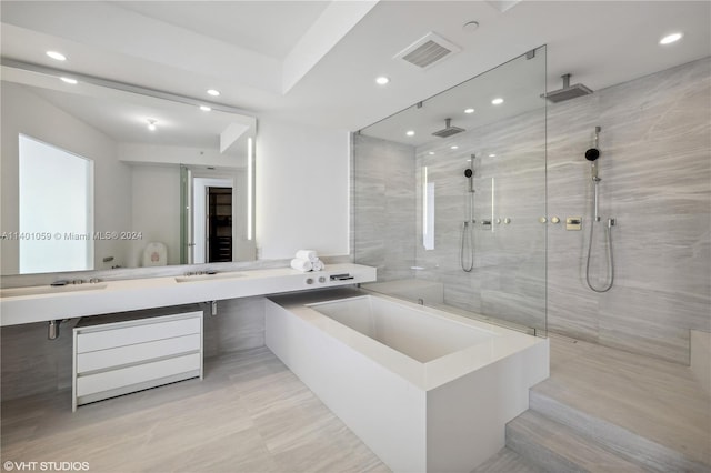 bathroom featuring tile floors, vanity with extensive cabinet space, and separate shower and tub